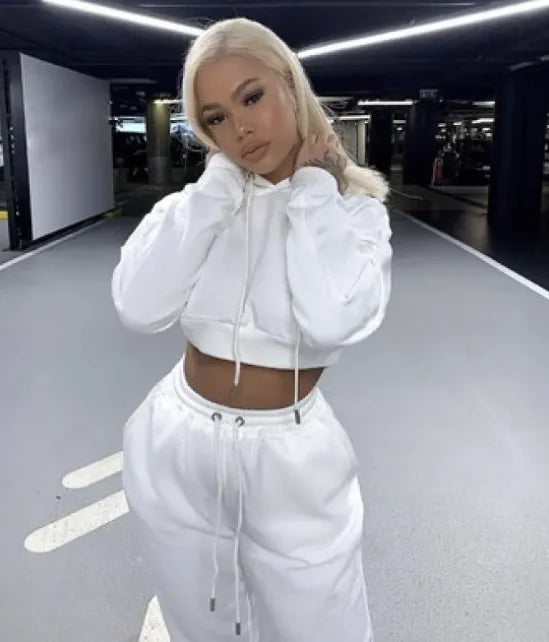 Person wearing a white hoodie and pants in an indoor setting