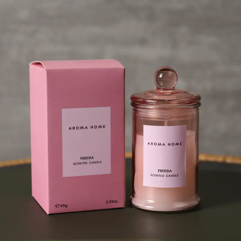 Aroma Home Freesia scented candle and packaging on a dark surface with a gray background