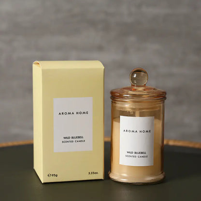 Aroma Home Wild Bluebell scented candle and packaging on a dark surface with a gray background