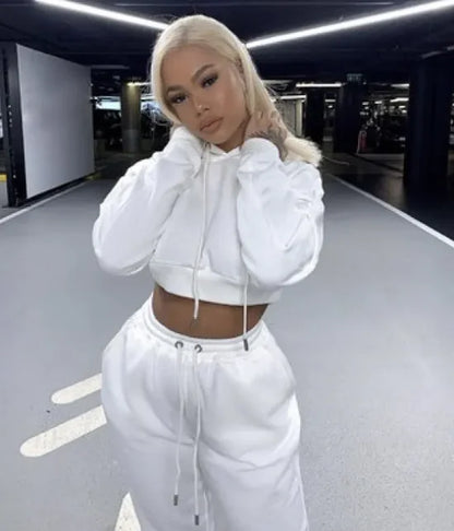 Person wearing a white hoodie and pants in an indoor setting